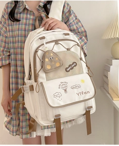 Detail of white canvas school backpack with khaki trim and functional mesh pockets