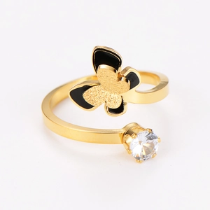 Macro detail of golden butterfly ring with black oil finish and sparkling cubic zirconia