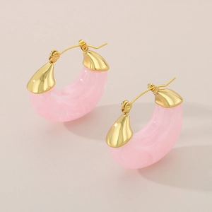 Detailed macro view of pink marble resin U-shaped earrings with gold metal clasp