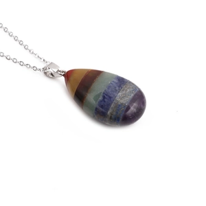 Detailed view of chakra crystal pendant with seven-color gemstones on silver chain