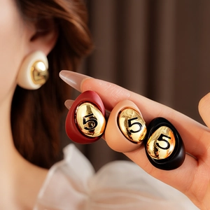 Detail of tear-drop enamel earrings in four colors with gold number five engraving