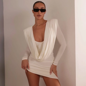 Détail d'une robe moulante blanche à manches longues avec décolleté plongeant en V et drapé