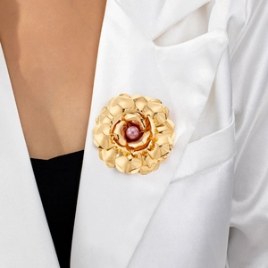 Fashionable gold flower brooch with pink pearl set on a white blazer lapel for women
