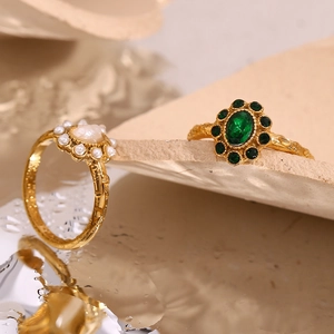 Detailed shot of 18K gold plated ring set with green emerald stone and white pearl