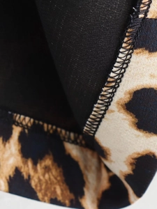 Macro view of leopard print fabric with neat black overlock stitching and soft lining