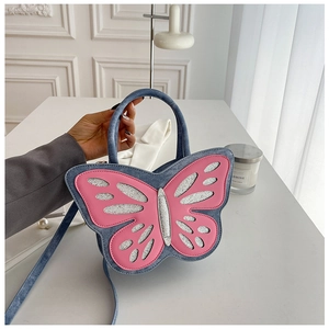 Detail of blue denim butterfly handbag featuring pink leather cutouts and sequins