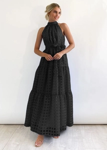 Macro detail of black tiered maxi dress featuring textured plaid jacquard fabric and belt