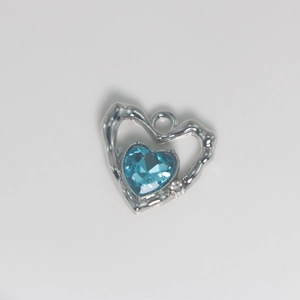Silver heart-shaped pendant with large blue gemstone and small clear crystal accent