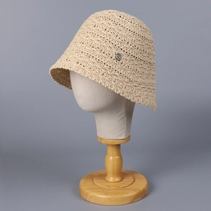 Women's beige crochet straw bucket hat with breathable knit pattern and metal accent