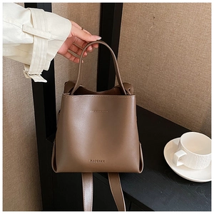 Detail shot of vintage dark brown bucket bag with smooth leather texture and top handle