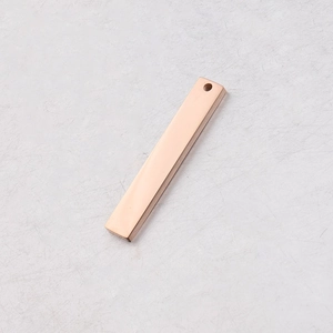 Close-up of a polished rose gold rectangular stainless steel pendant with a single hole