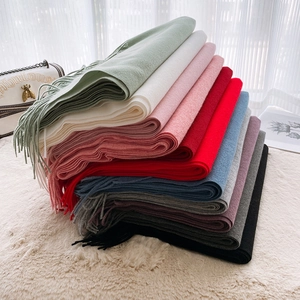 Stack of colorful cashmere-feel scarves with tassels in mint, pink, blue, and gray colors