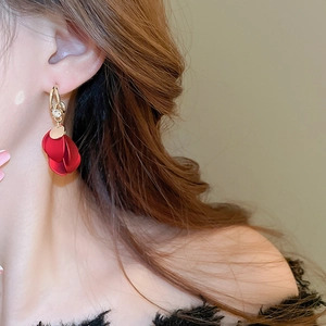 Close-up of red matte flower petal drop earrings with gold hooks and zircon detail