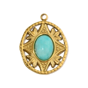 Detailed close-up of a vintage round gold-plated pendant with blue stone inlay