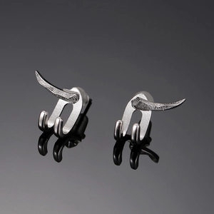 Detailed view of silver hook studs with dual-spike punk design and mirrored reflection