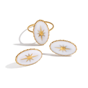 Bague ovale dorée avec émail blanc et motif d'étoile sur un anneau torsadé