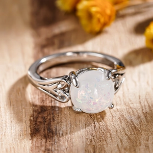 Vintage style silver ring featuring a round opal stone and hollow heart pattern