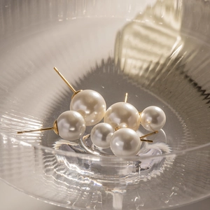 Boucles d'oreilles vintage en perles blanches avec clous dorés dans un verre chic