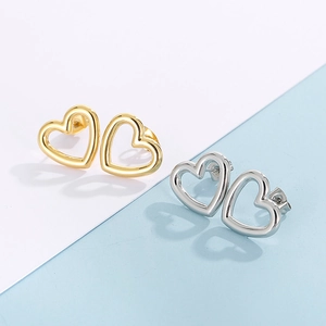 Détail des boucles d'oreilles cœur ajouré en acier inoxydable fini or et argent poli