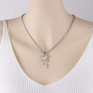 Macro detail of silver rose pendant on stainless steel chain necklace on model