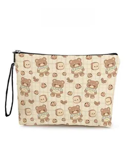 Detail of cartoon bear and cookie pattern on beige checkered cosmetic storage bag