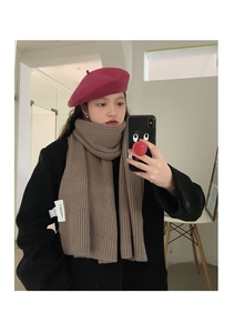 Detail of brown ribbed knit scarf paired with a magenta wool beret for winter style
