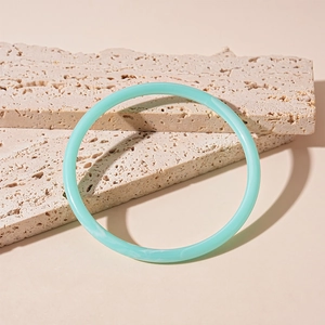 Détail du bracelet en acrylique vert menthe avec marbrures sur pierre blanche
