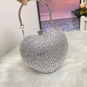 Macro detail of heart-shaped evening bag with sparkling rhinestones and silver ring handle
