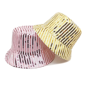 Close-up of sparkling sequin bucket hats in pink, gold, and white striped patterns