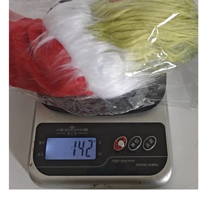 Detail shot of the Christmas gnome plush showing its weight of 142g on a digital scale
