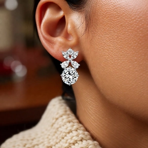 Dettaglio degli orecchini a fiore in argento con zirconi brillanti indossati dalla modella