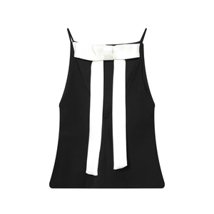 Haut caraco noir sans manches avec un grand nœud en satin blanc sur fond blanc épuré