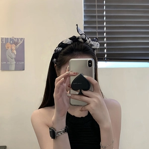Mirror selfie showing a black and white floral fabric headband on a woman's hair