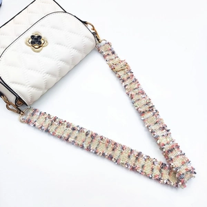 Adjustable beige woven shoulder strap with gold clover clasp and colorful braided pattern