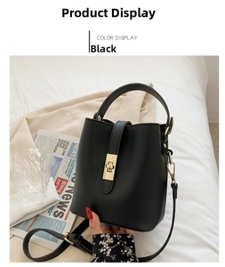 Detail view of a black leather bucket bag with gold twist lock and adjustable shoulder strap