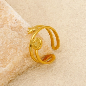 Detail of adjustable gold star and sun disk ring on natural mineral stone