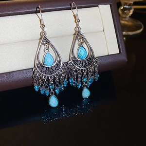 Detail of vintage bohemian teardrop earrings with sky blue rhinestones and silver tassels