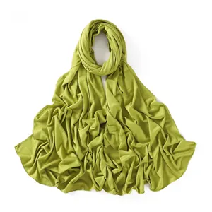 Close-up of light green modal jersey fabric texture and fine stitched edge detailing
