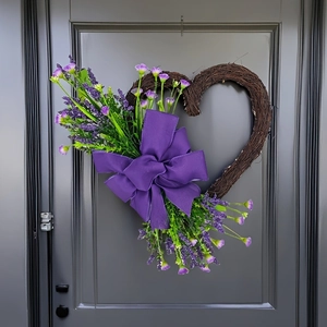 Close-up of heart-shaped rattan wreath with purple lavender and mesh bow on a door