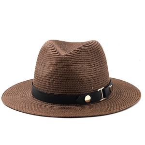 Detailed close-up of brown straw fedora hat featuring a black belt with gold metal studs
