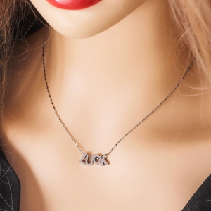 Elegant stainless steel LUCK letter pendant necklace worn by a model on a delicate chain