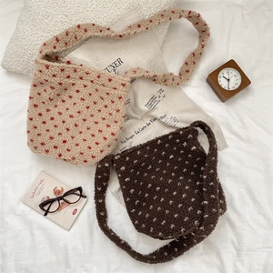 Detail of plush bucket bags with heart patterns in apricot red and coffee white tones