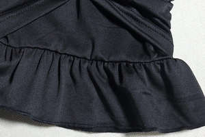Detail of black knitted stretch fabric with elegant ruffles and precise double stitching