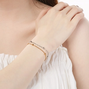 Close-up of double-layered stainless steel bead bracelets in gold and silver finish