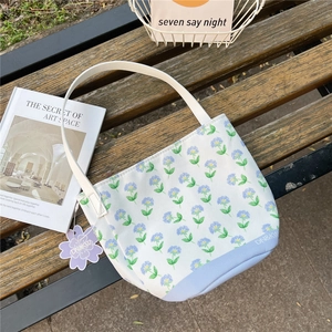 Detailed macro view of canvas bucket bag with blue floral print on wooden bench