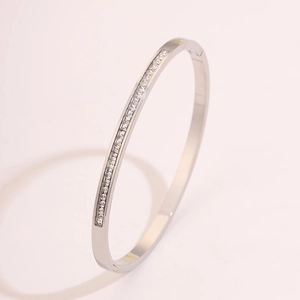 Detail view of silver stainless steel bangle with a row of square cubic zirconia stones