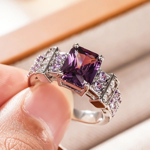 Macro detail of luxury vintage ring featuring a large rectangular purple gem with side pave diamonds