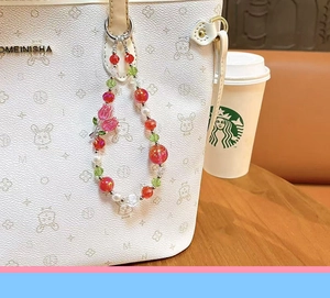 Close-up detail of handmade pink tulip flower beaded charm accessory on white tote bag