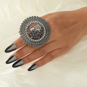 Retro boho hollow round silver ring with crystals on model's hand with fur background