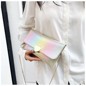 Iridescent laser clutch bag with heart clasp and gold chain strap shown on a model